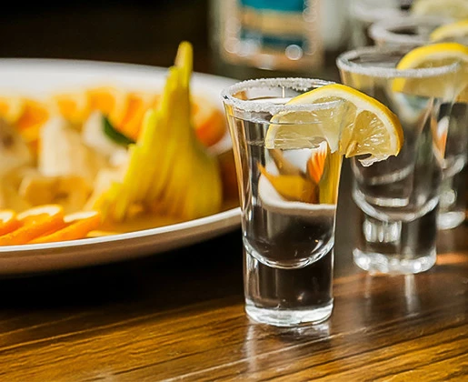 a group of shot glasses with a lemon wedge on them