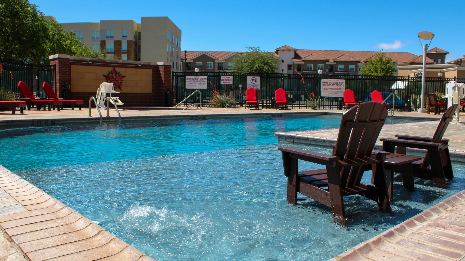 a pool with chairs and a fence