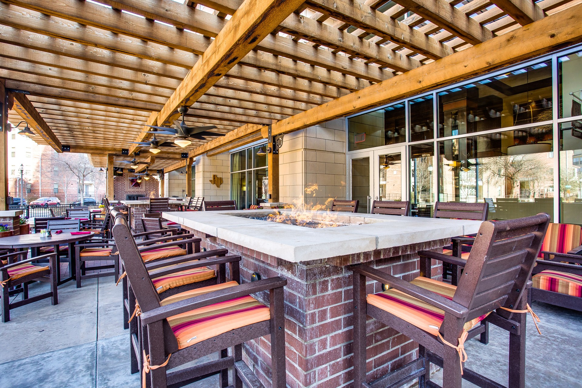 a patio with a fire pit and chairs