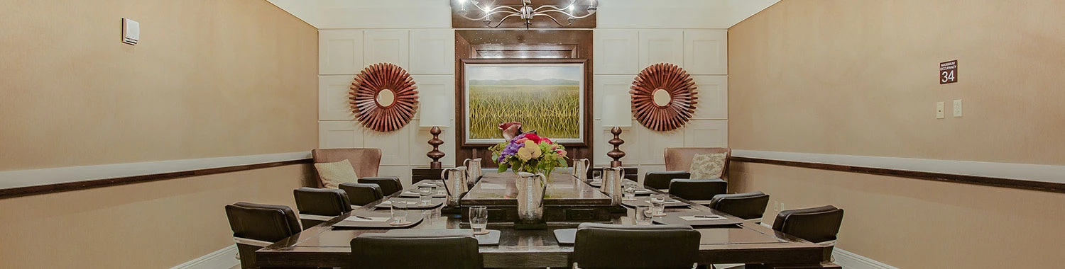 meeting venue with a screen at the front of the room and black chairs around a rectangular table
