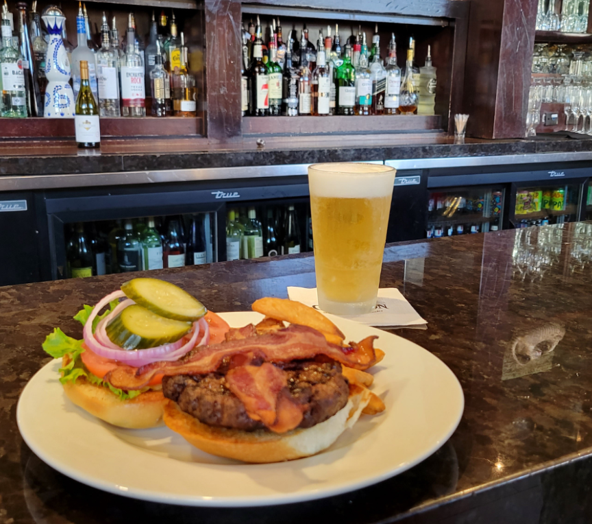 a plate of burger and bacon on a counter