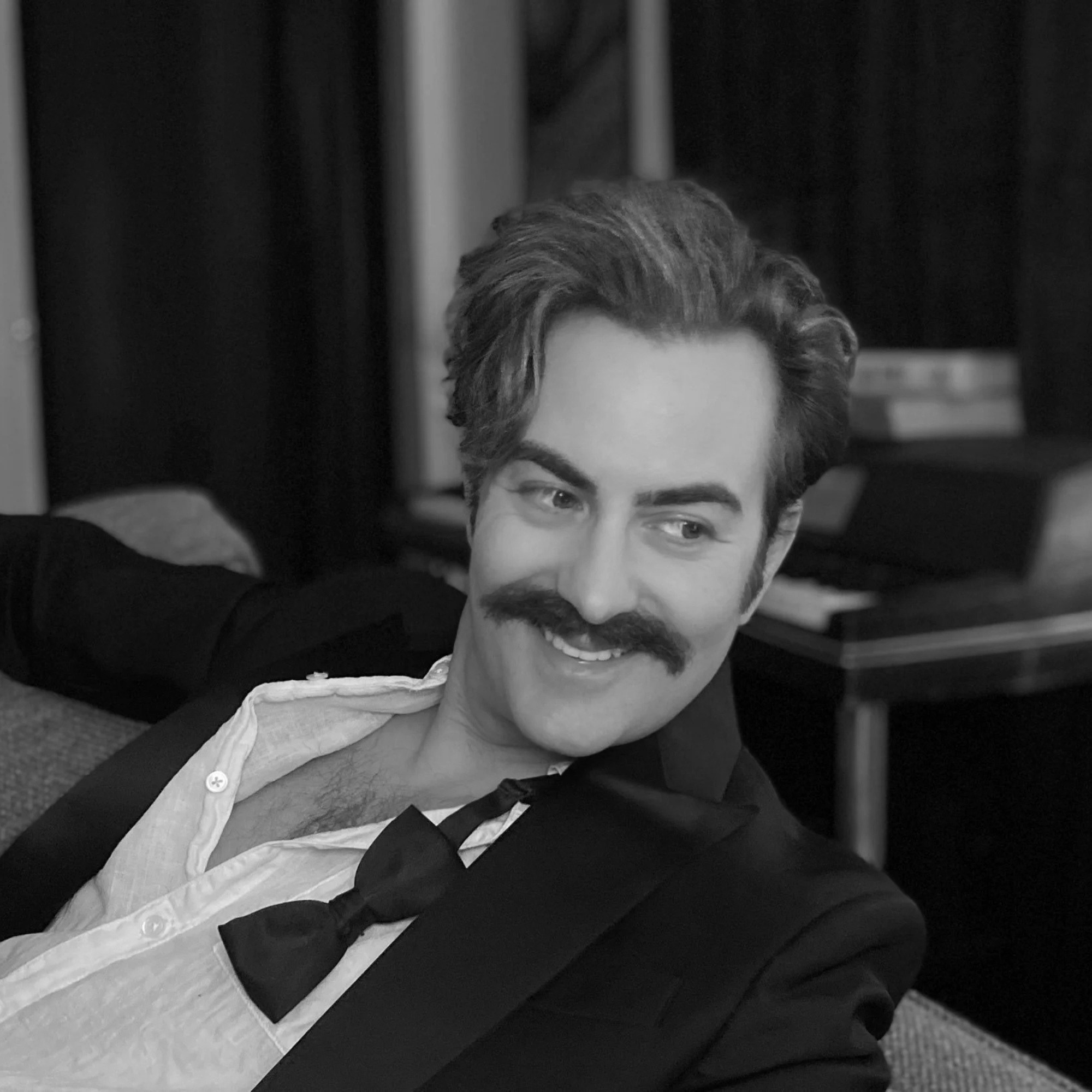 a man with a mustache sitting on a couch