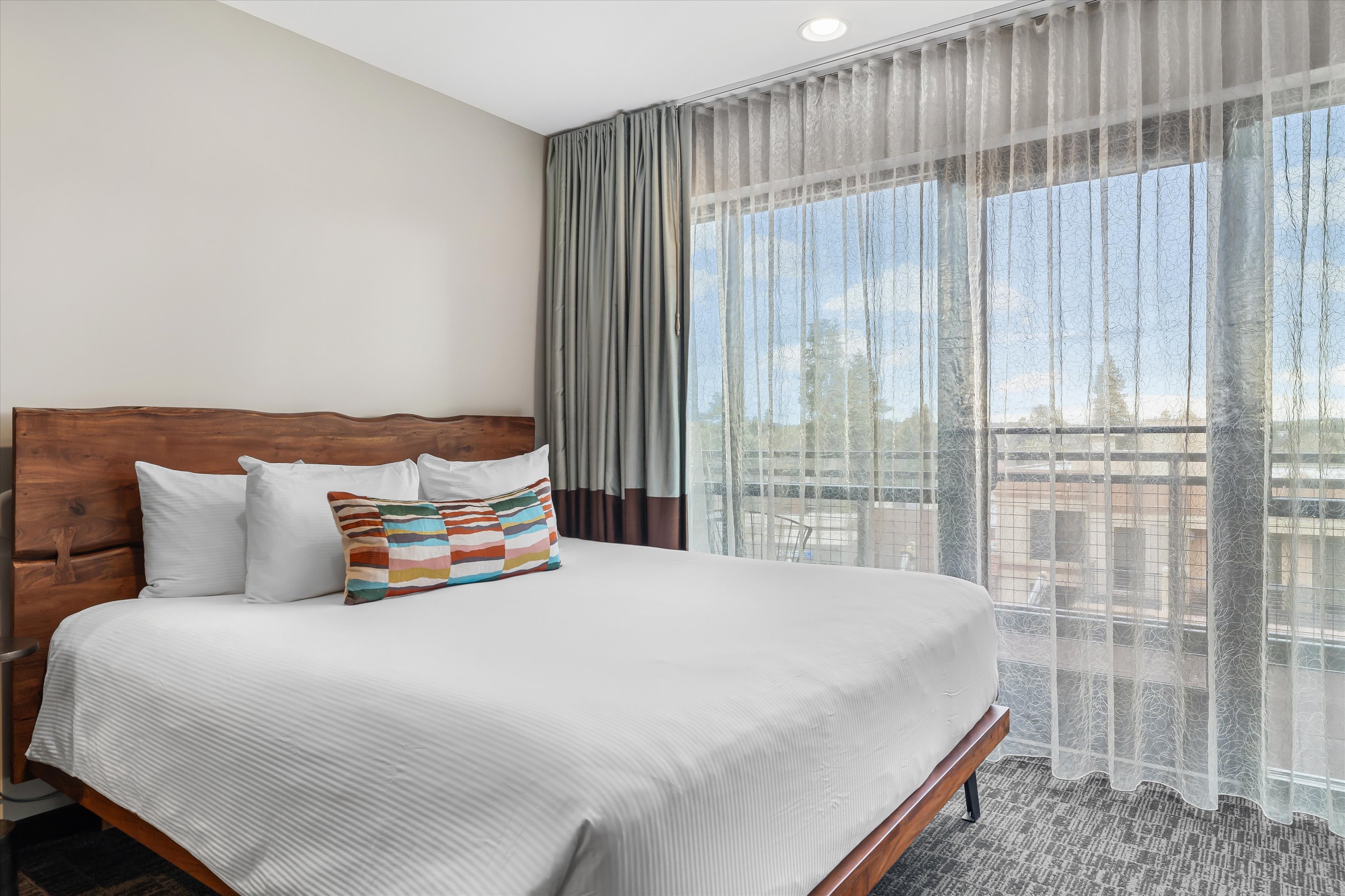 a bed with a colorful pillow