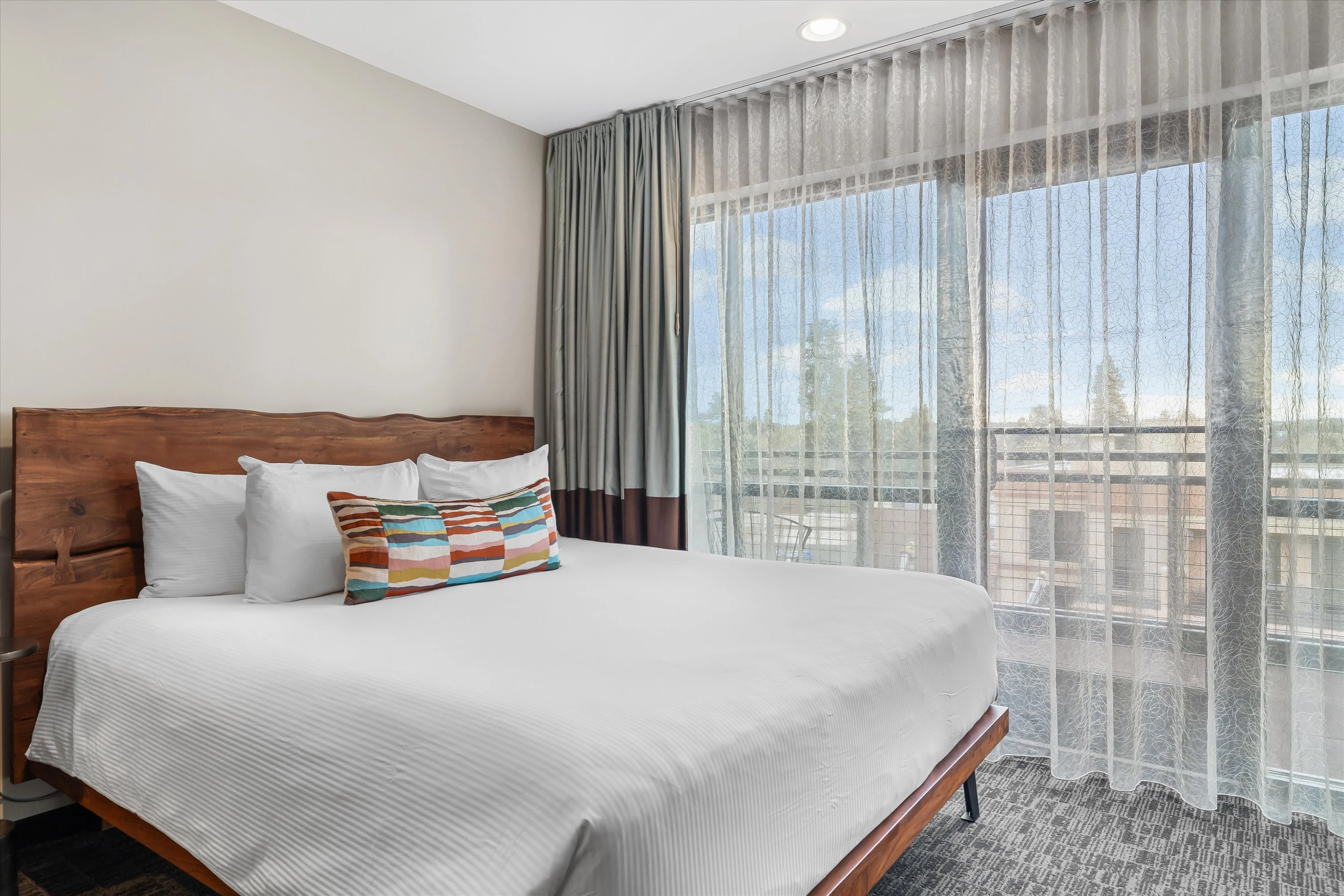 a bed with a colorful pillow