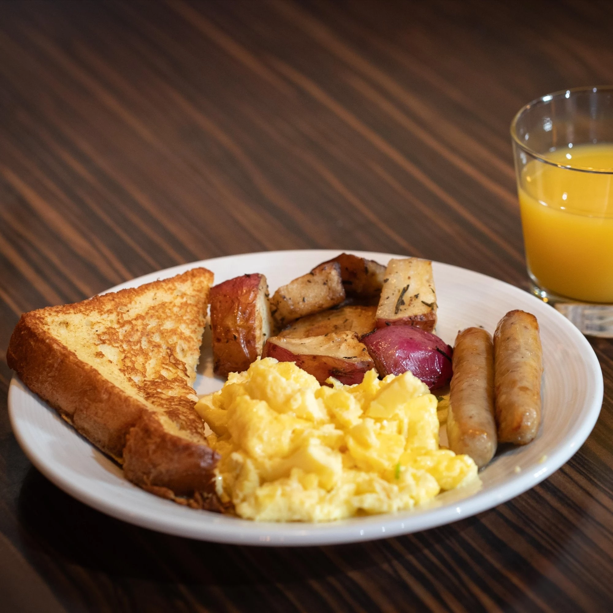 a plate of breakfast with toast eggs and sausages