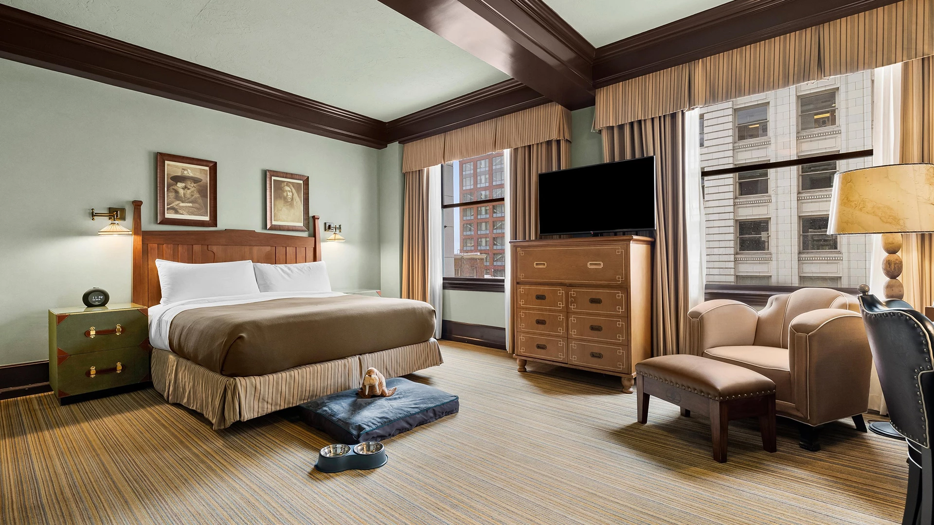 A hotel room with a bed, dresser, chair, and TV.