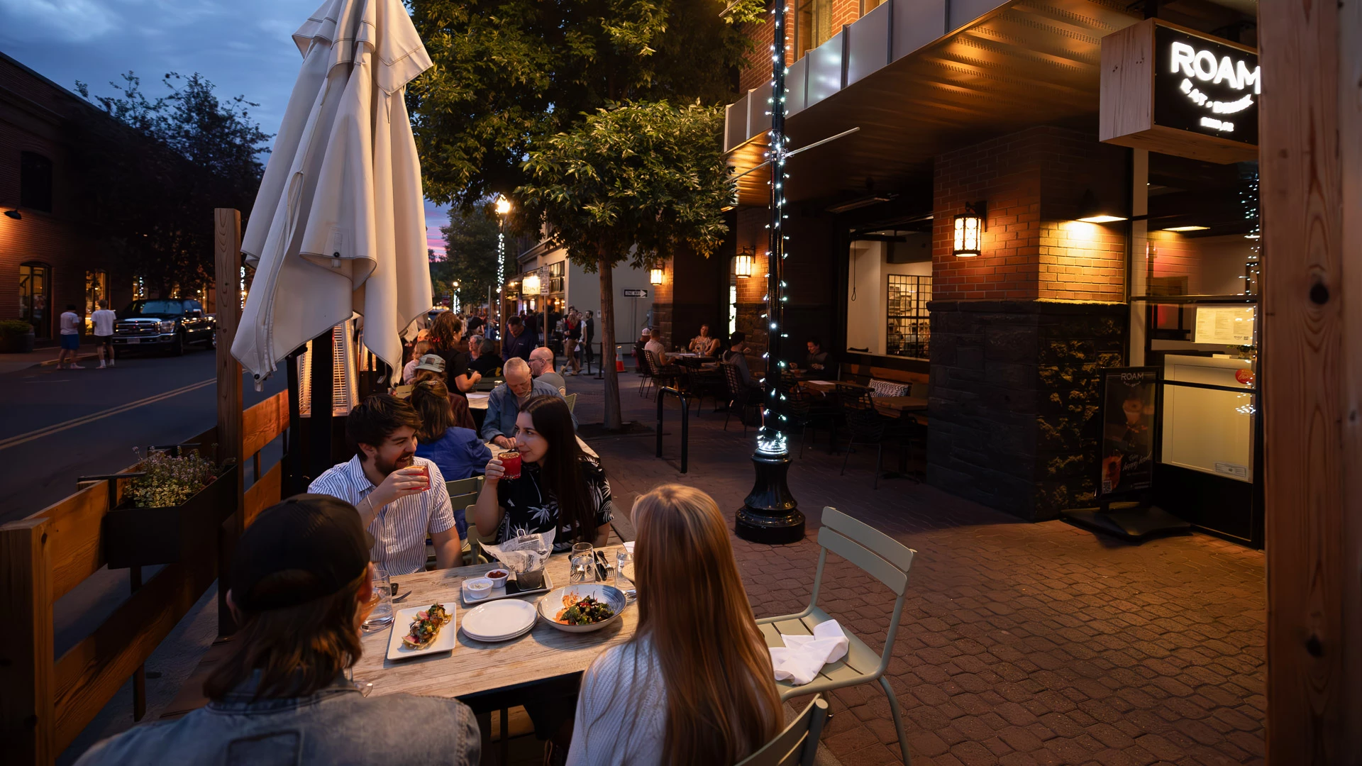a group of people sitting at a table outside a building