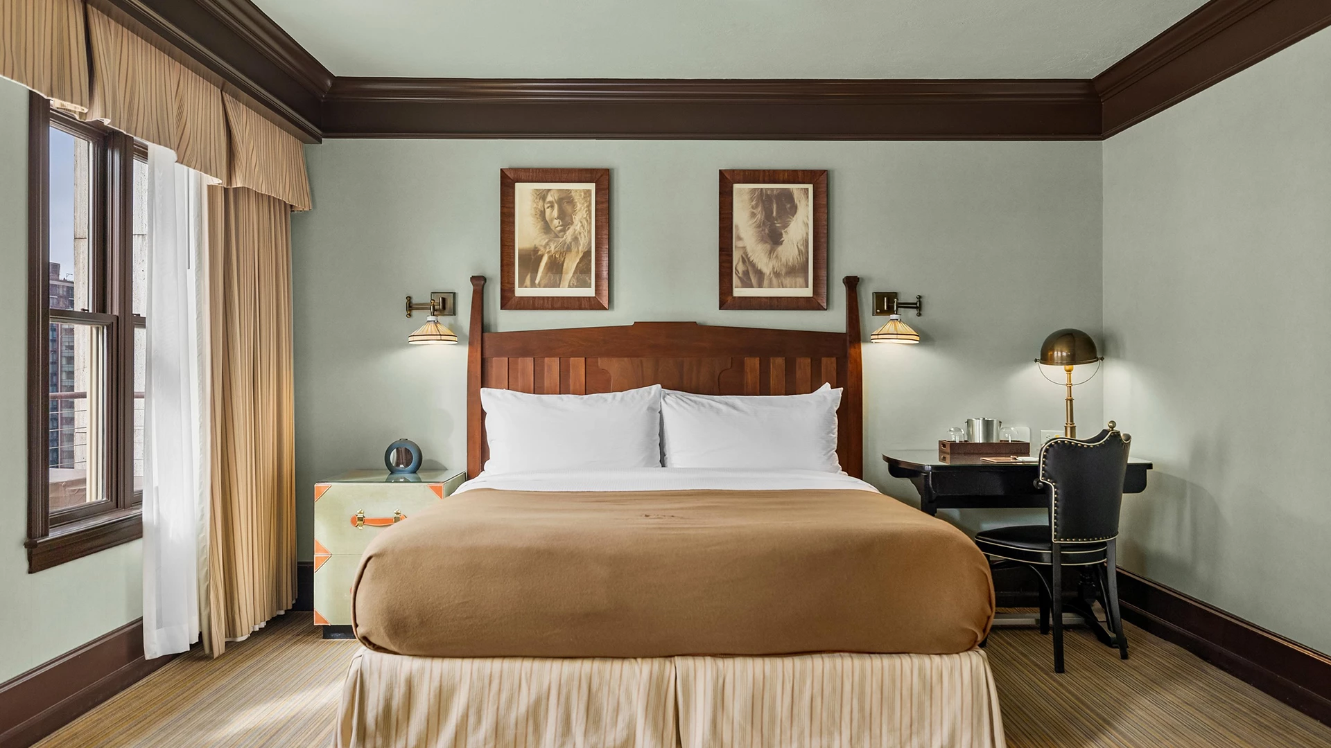 a bed with a wood headboard and a table with two lamps