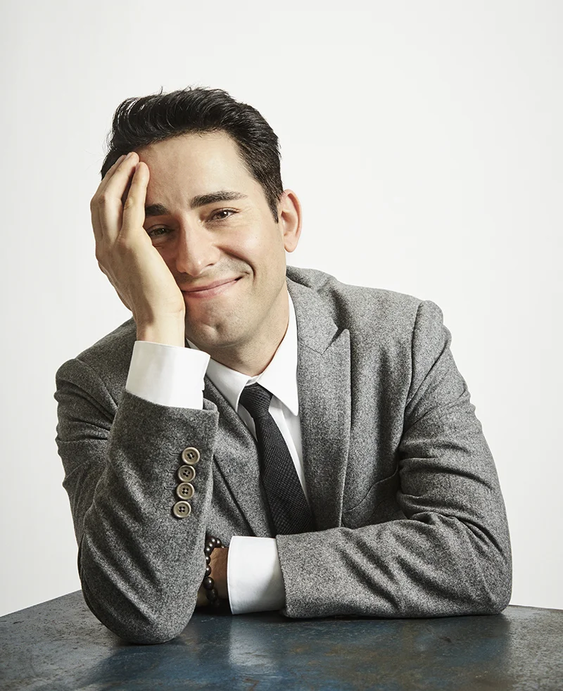 a man in a suit leaning on a table