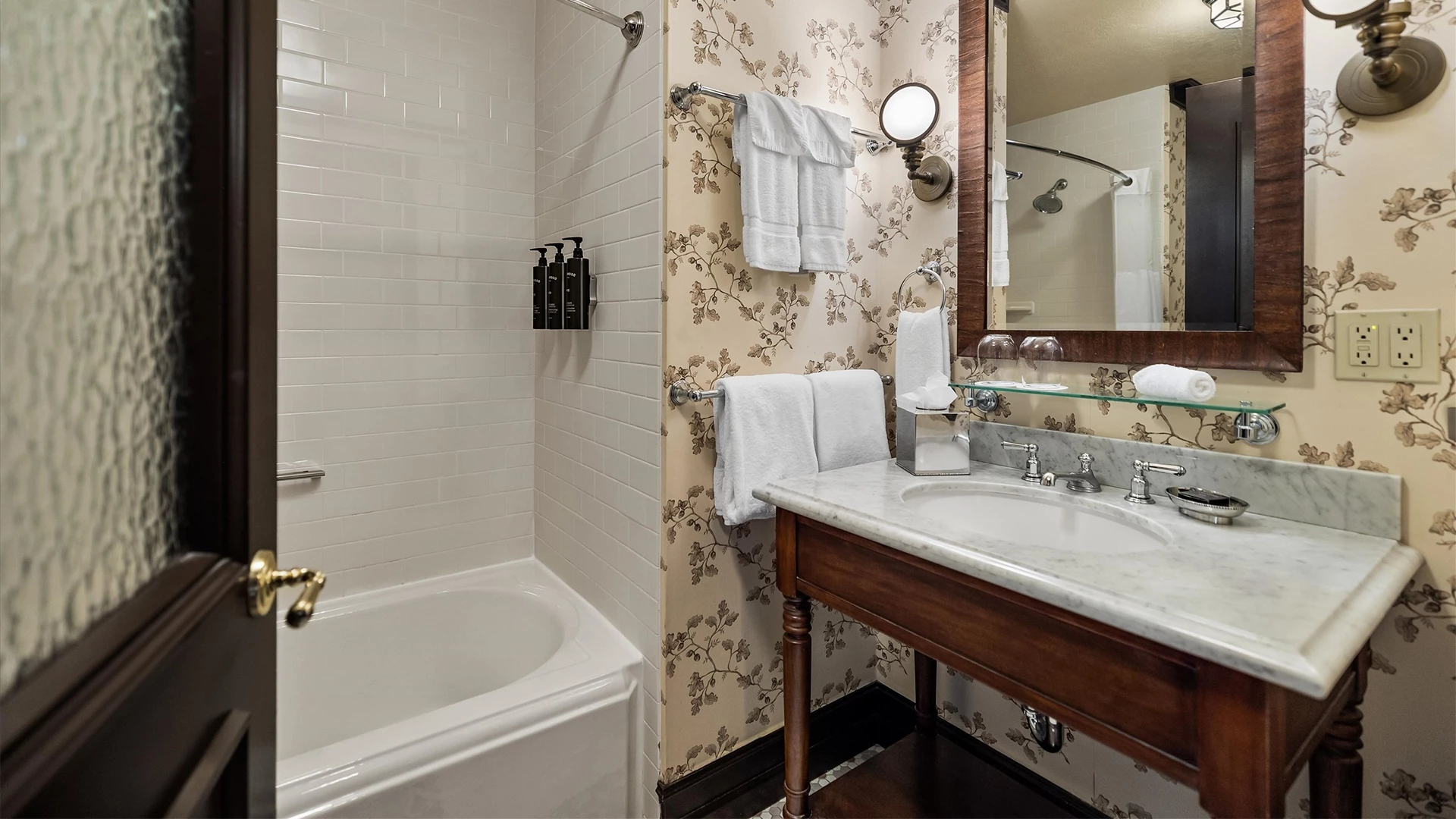 A bathroom with a sink, mirror, and tub.