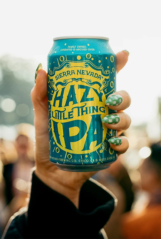 a hand holding a can of beer