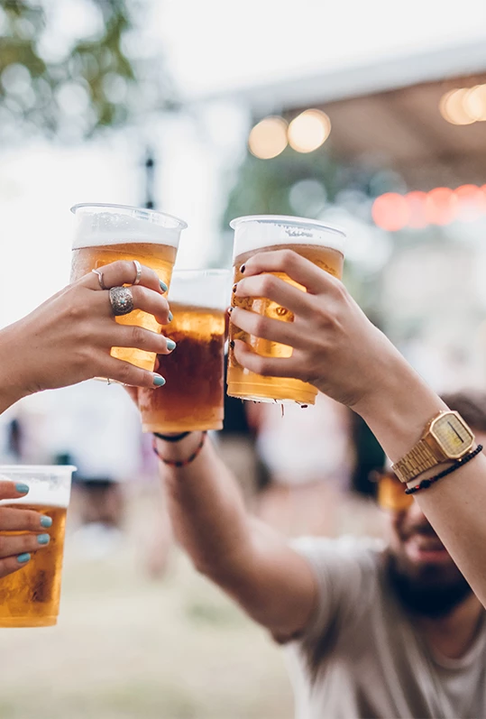 a group of people holding up glasses of beer