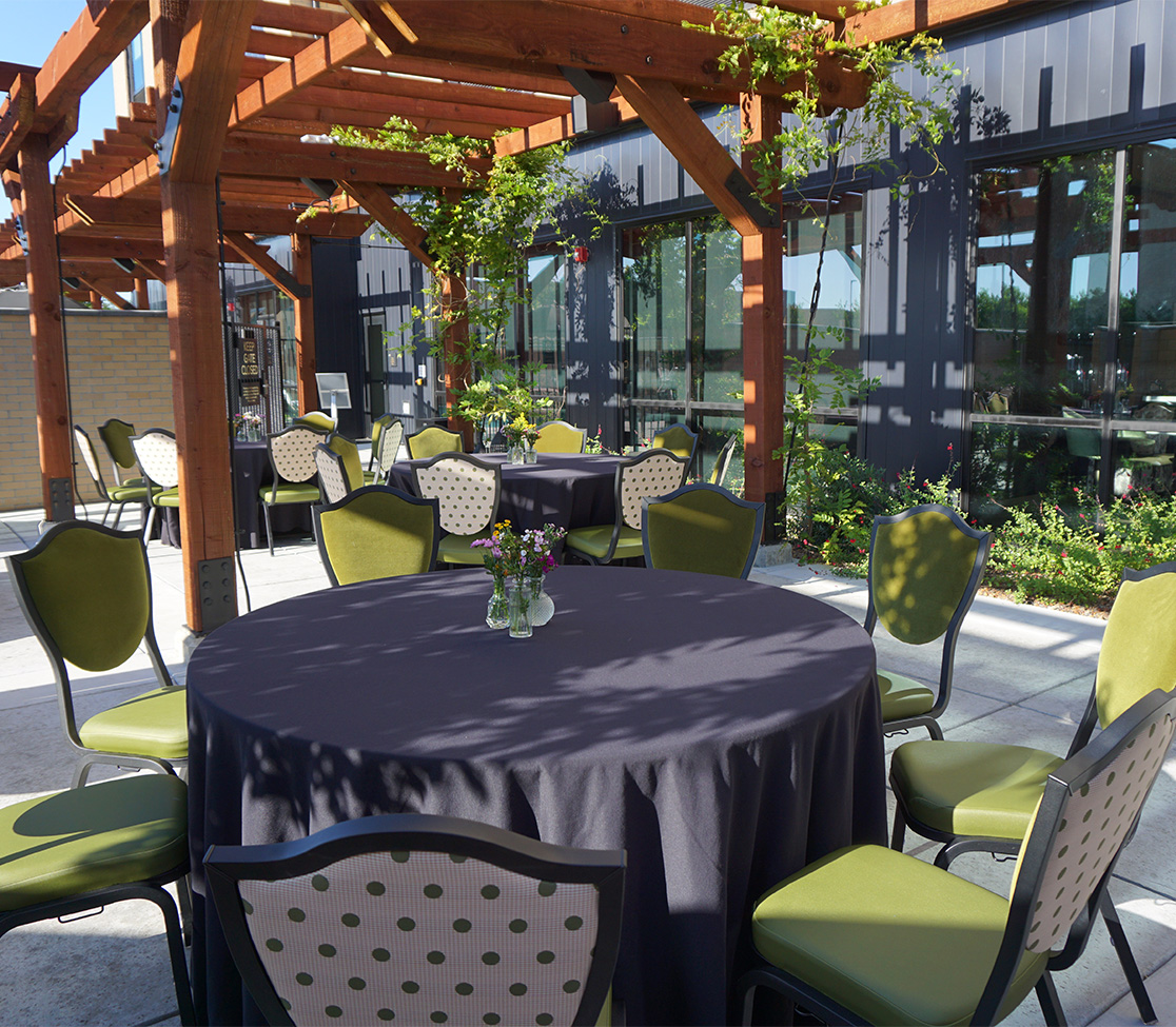 a table and chairs outside with a pergola