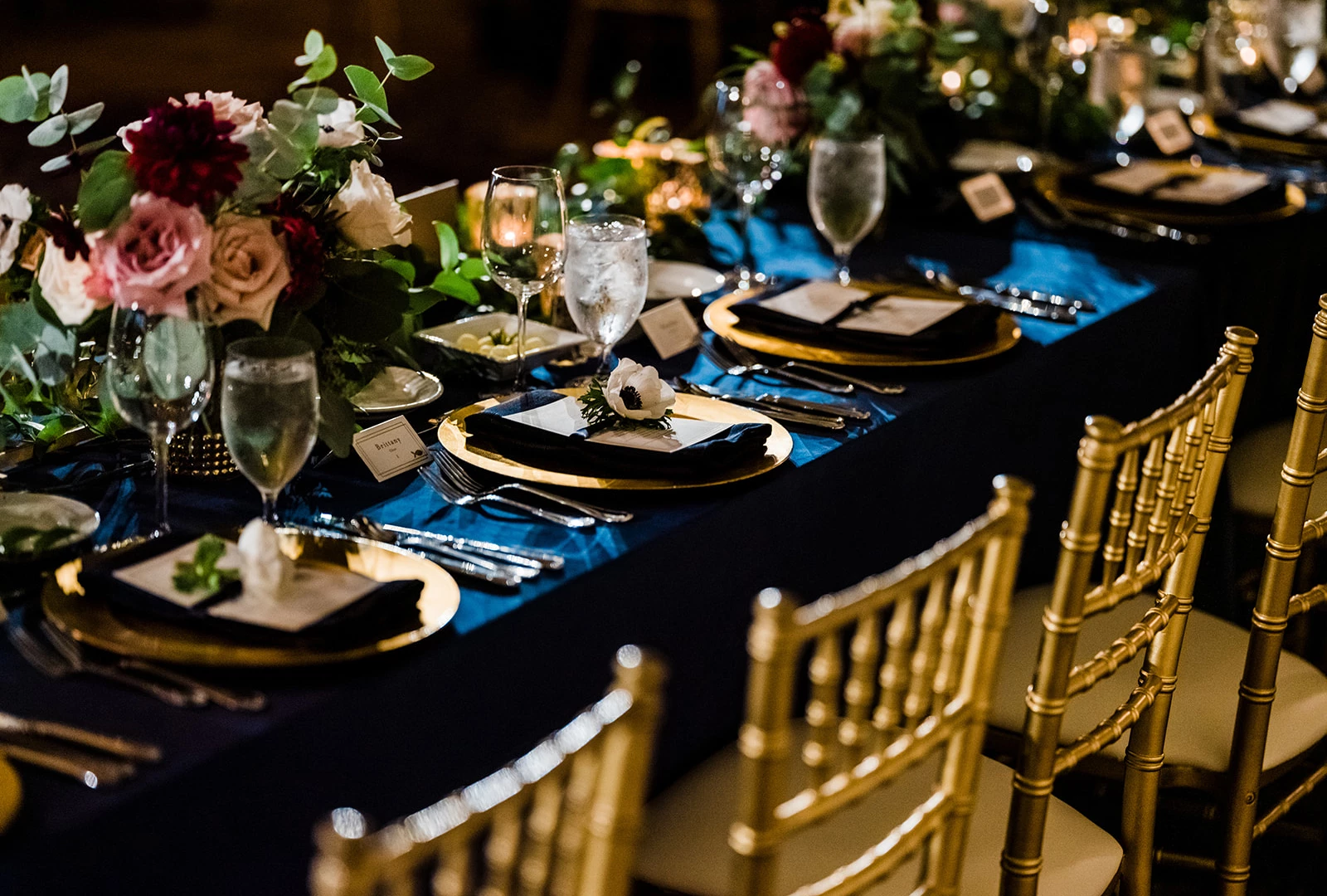 a table set with gold plates and glasses