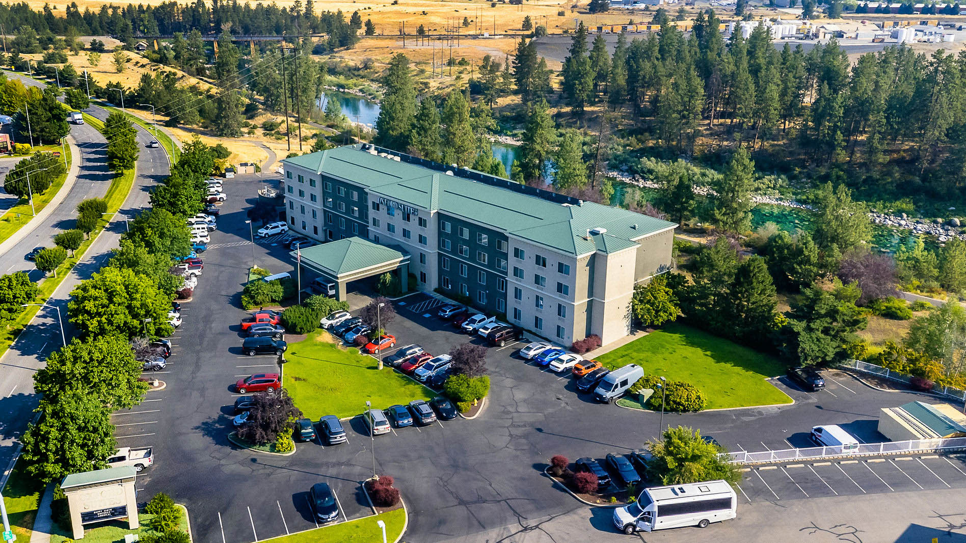 a building with parking lot and trees