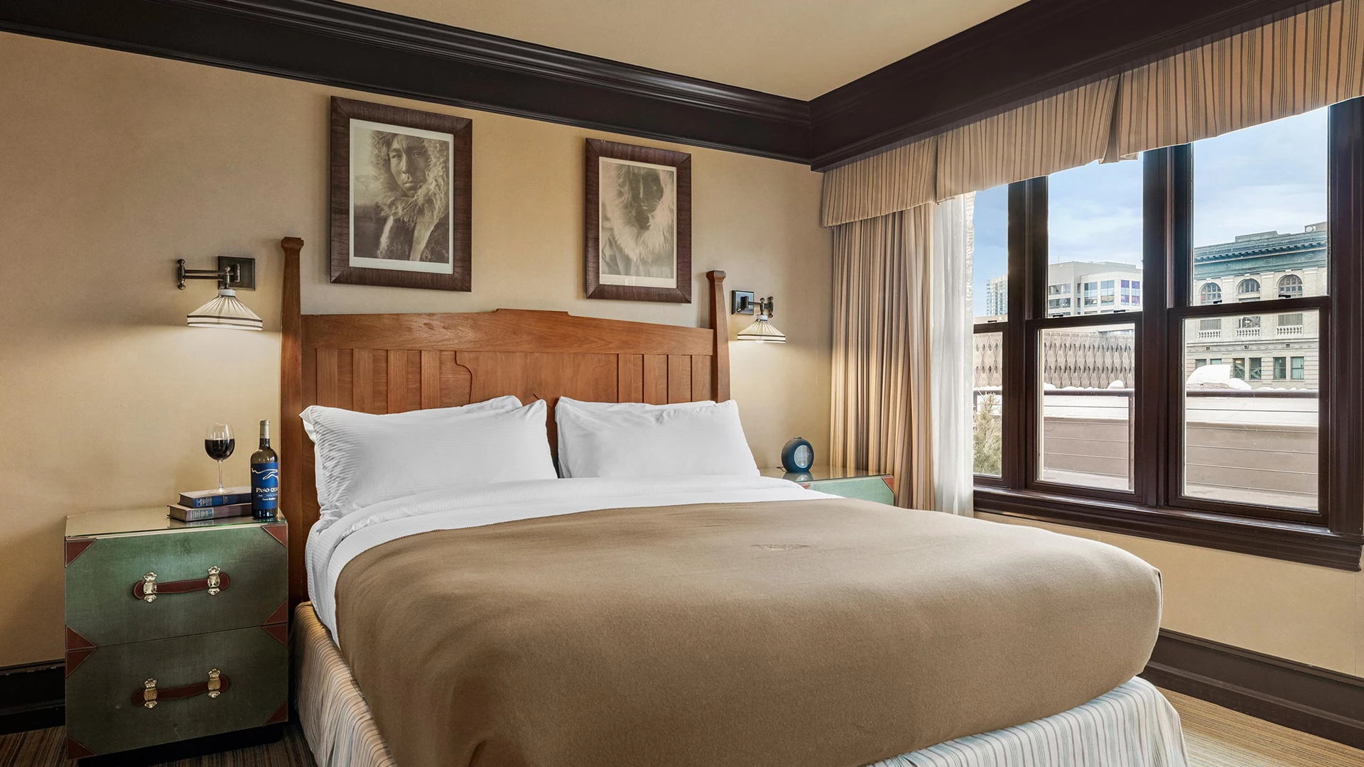 A hotel room with a bed, nightstand, and window