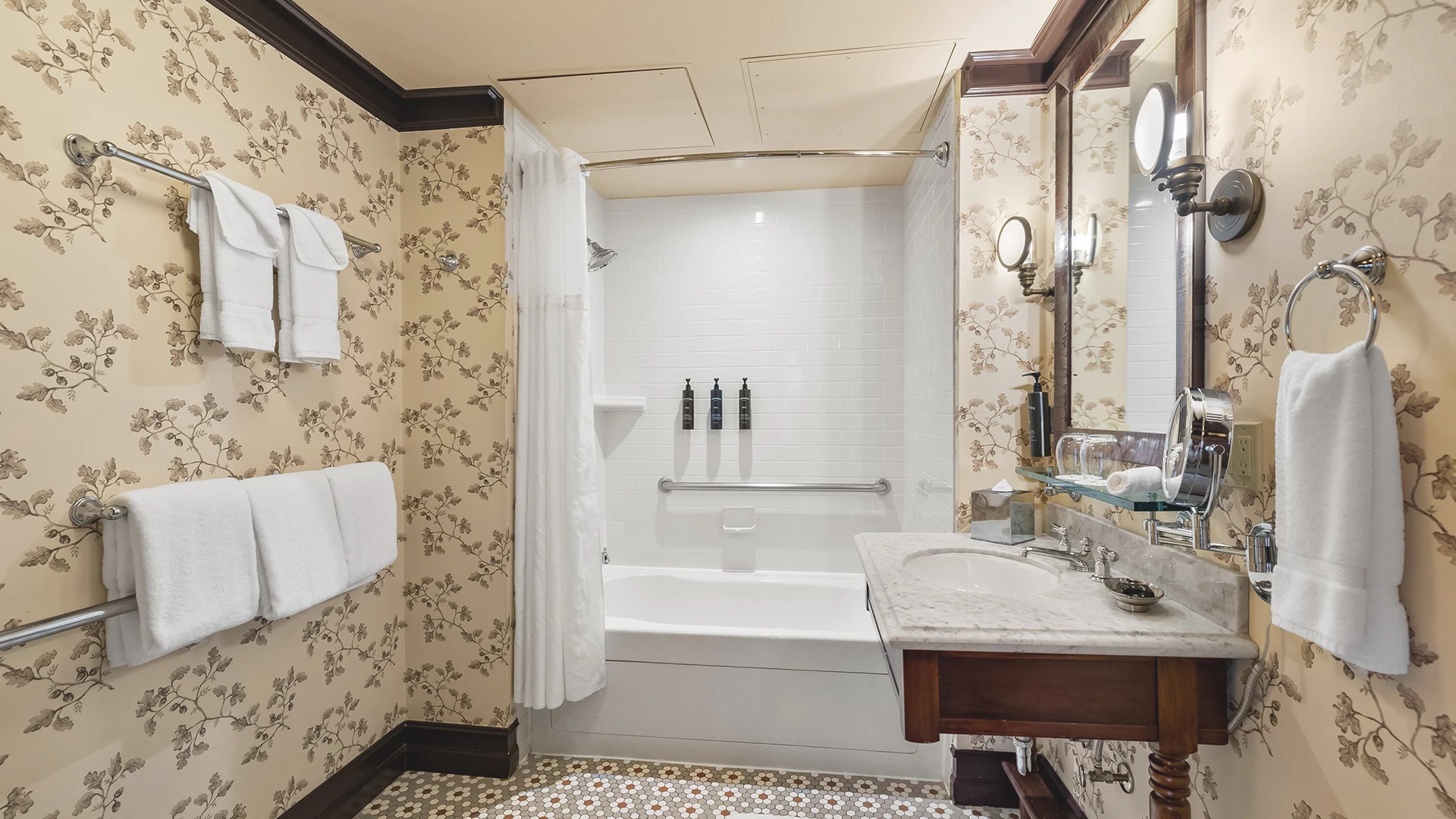A bathroom with a tub, sink, and mirror