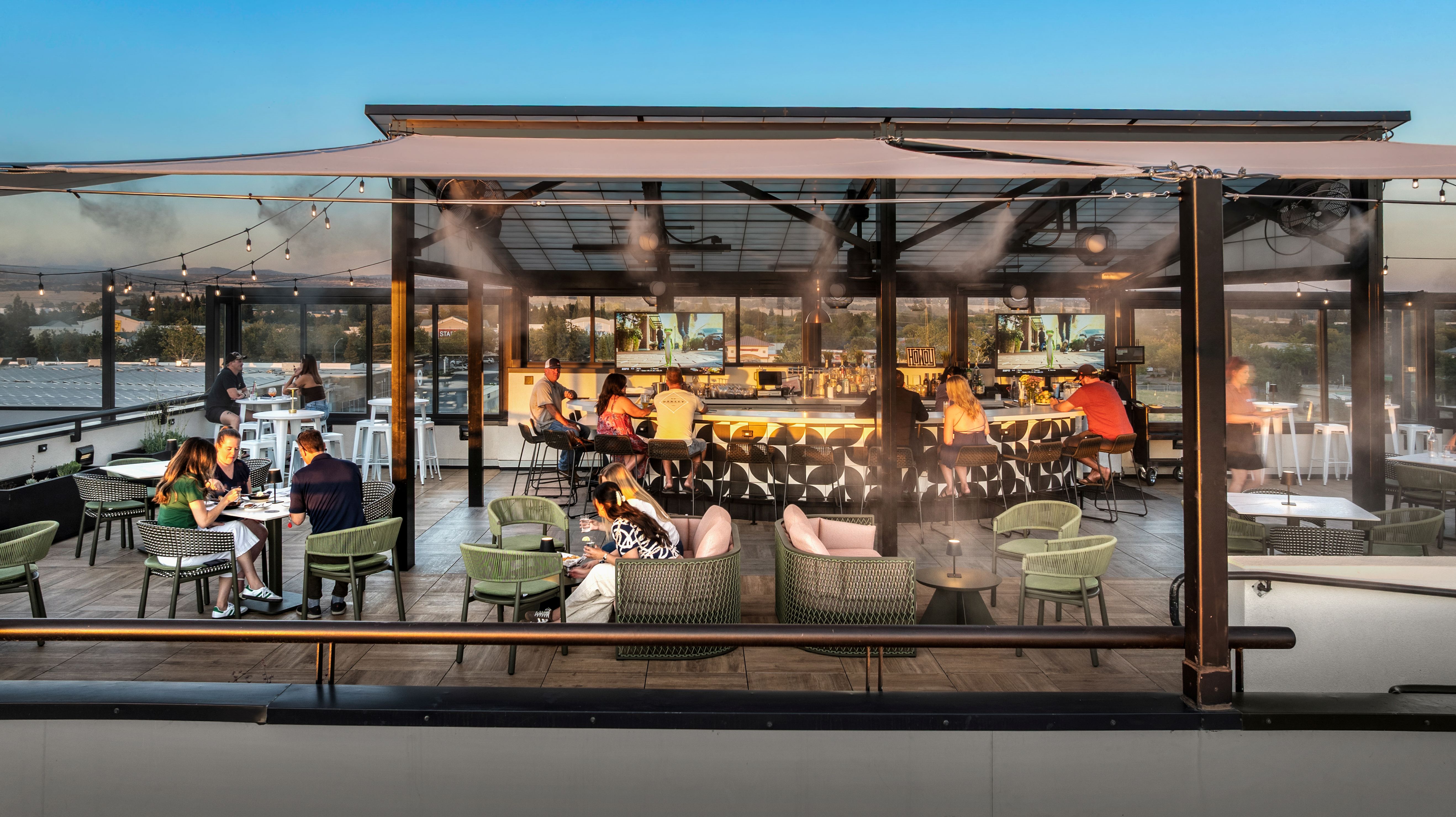 a group of people sitting at tables outside
