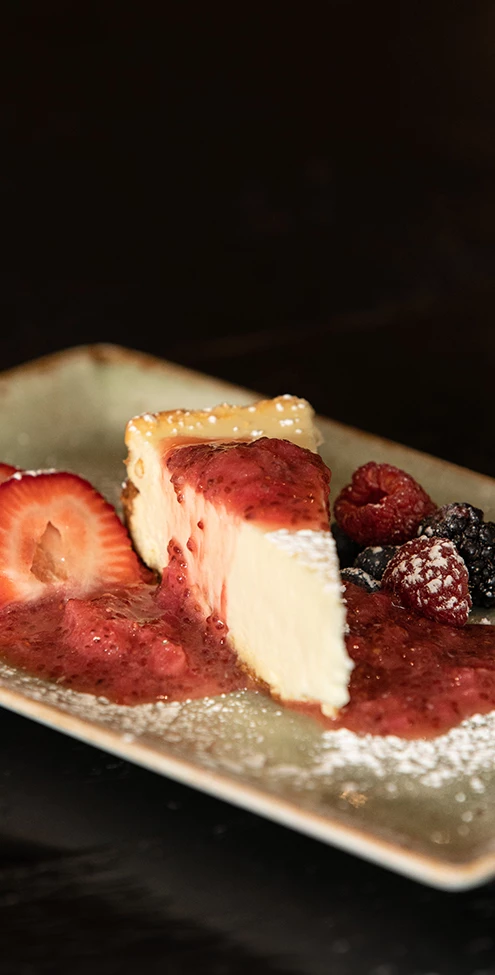 a plate of food with a slice of cheesecake and berries