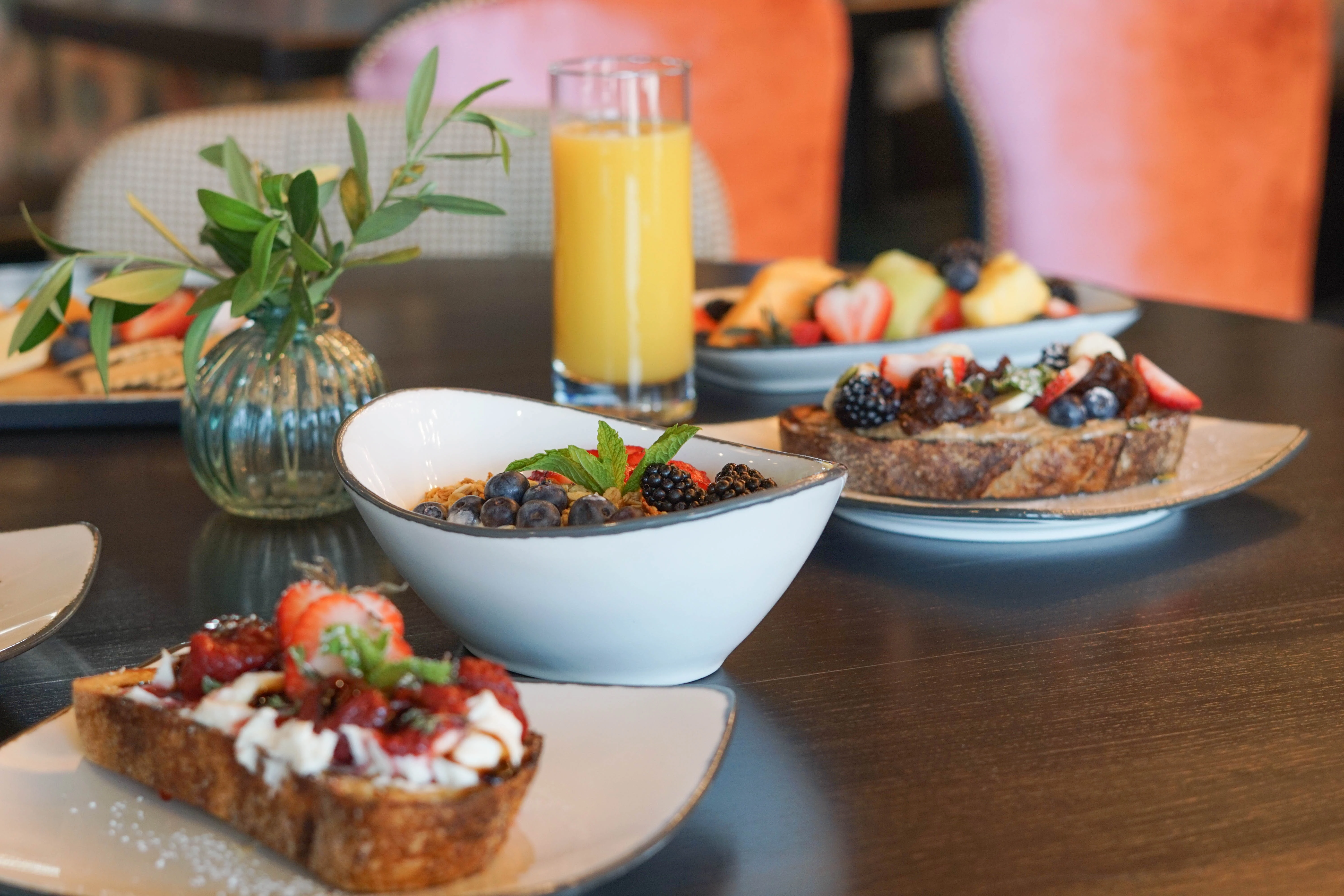 a table with plates of food and a glass of juice