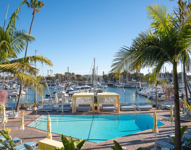 a pool with a dock and boats in the background