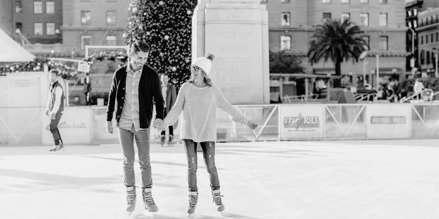 a man and woman holding hands on an ice rink