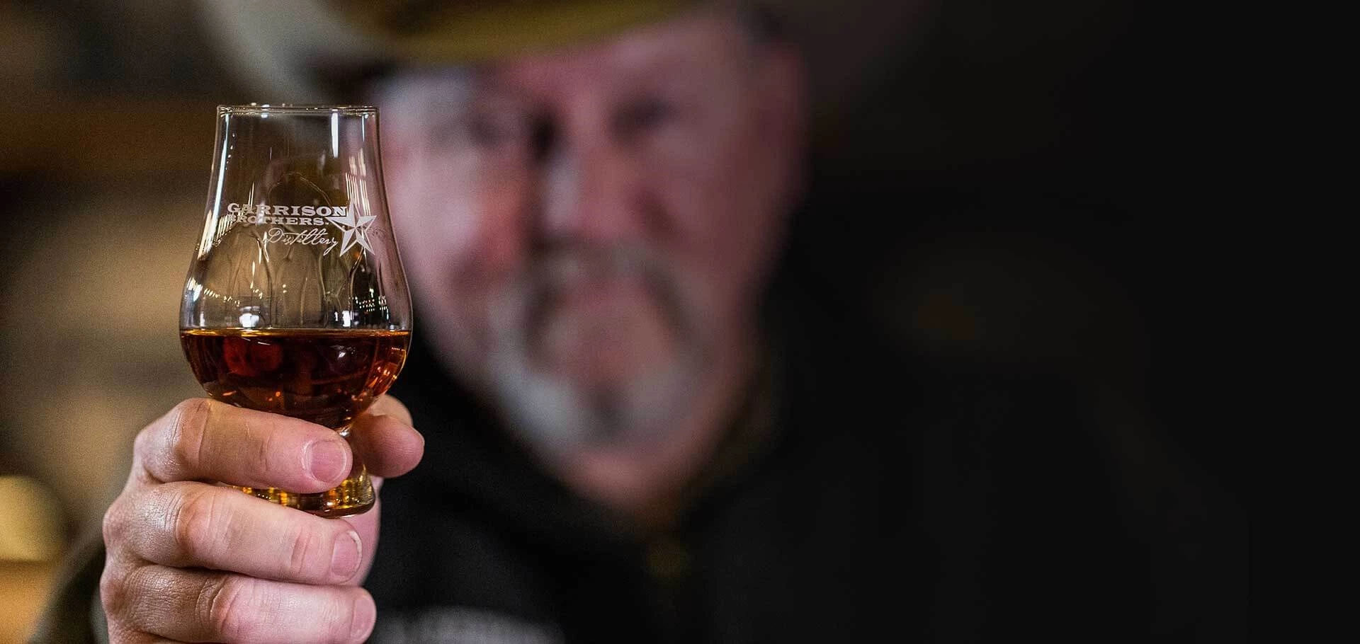 a man holding a glass of alcohol