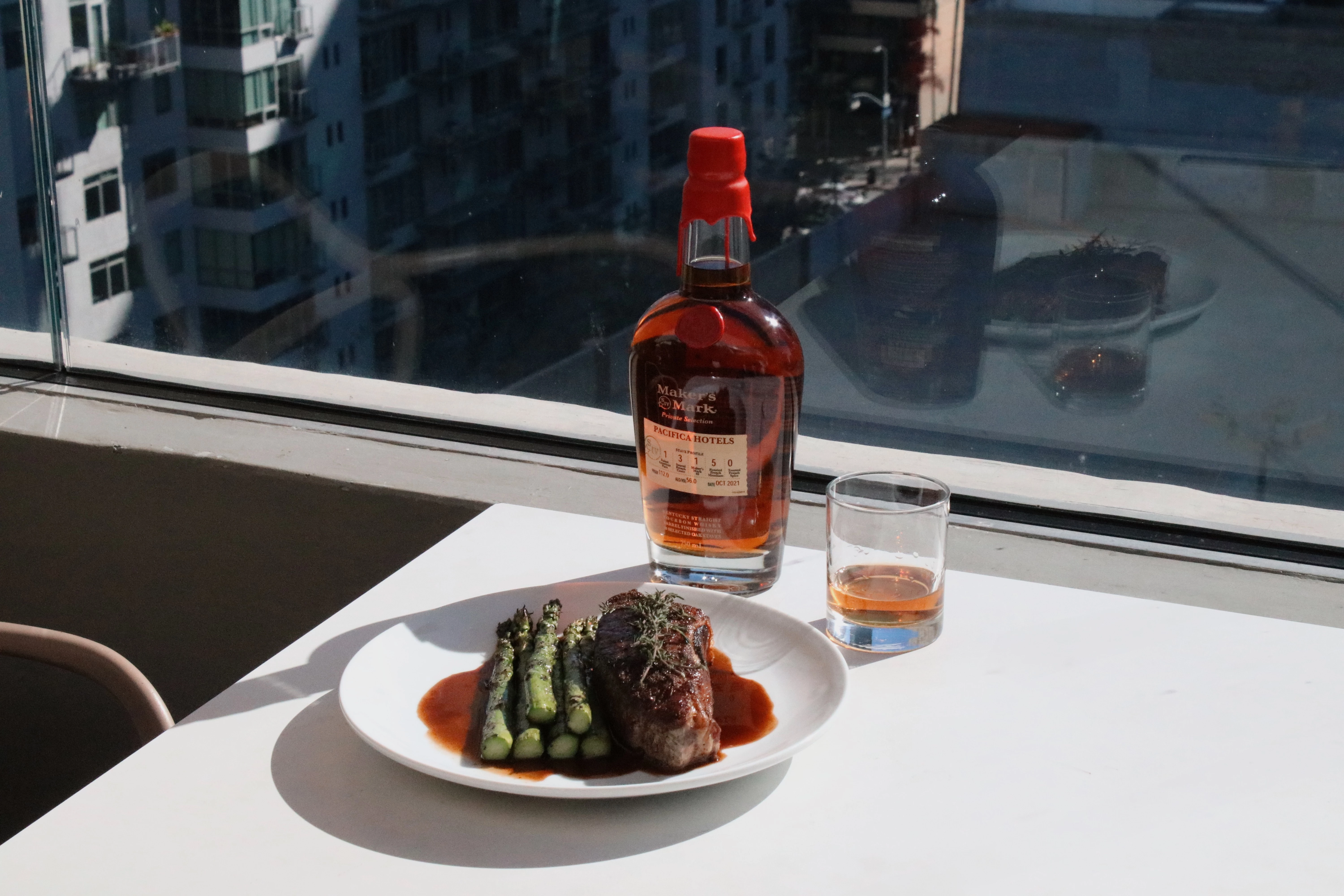 a plate of food and a glass of whiskey