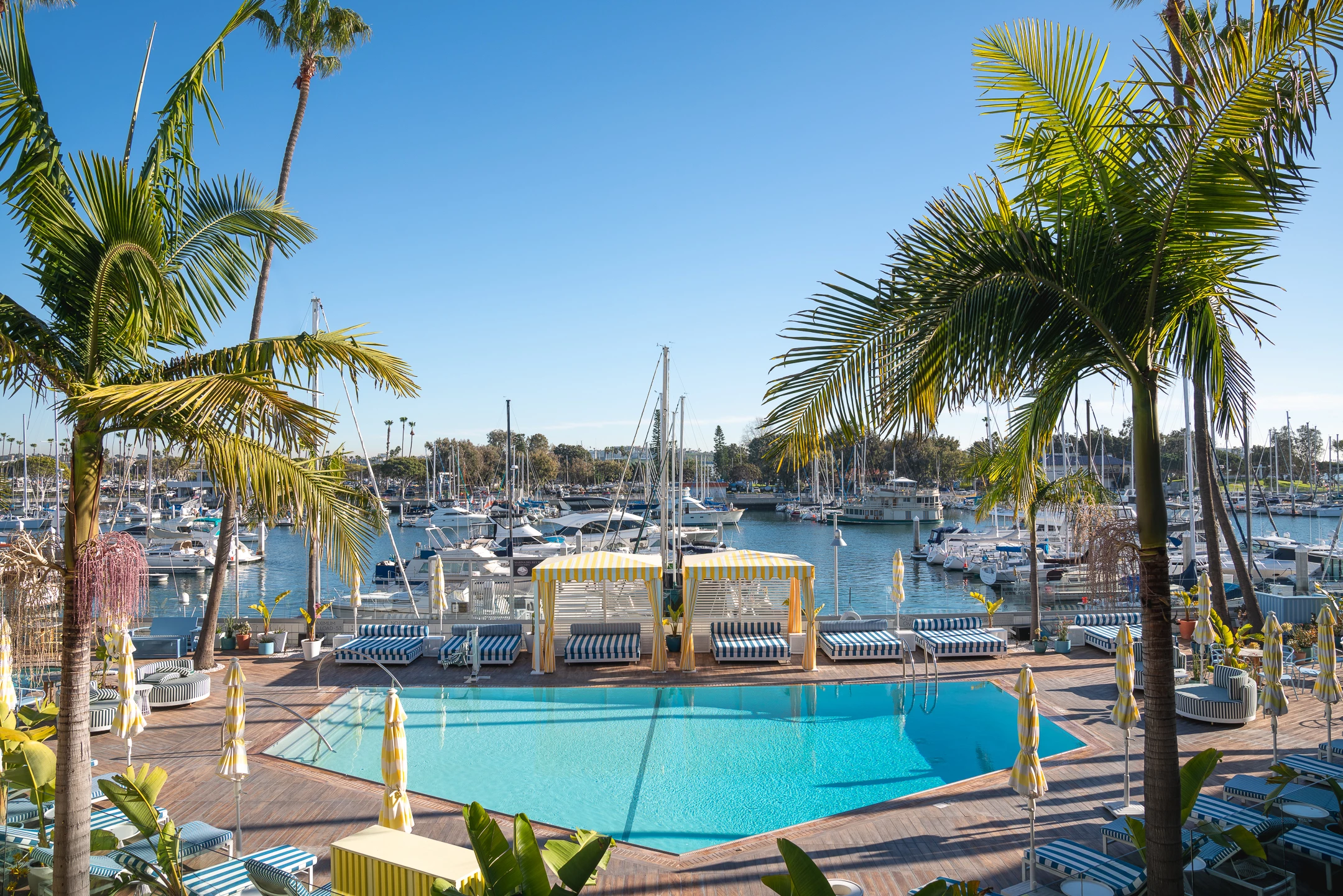 a pool with boats in it by a dock and palm trees