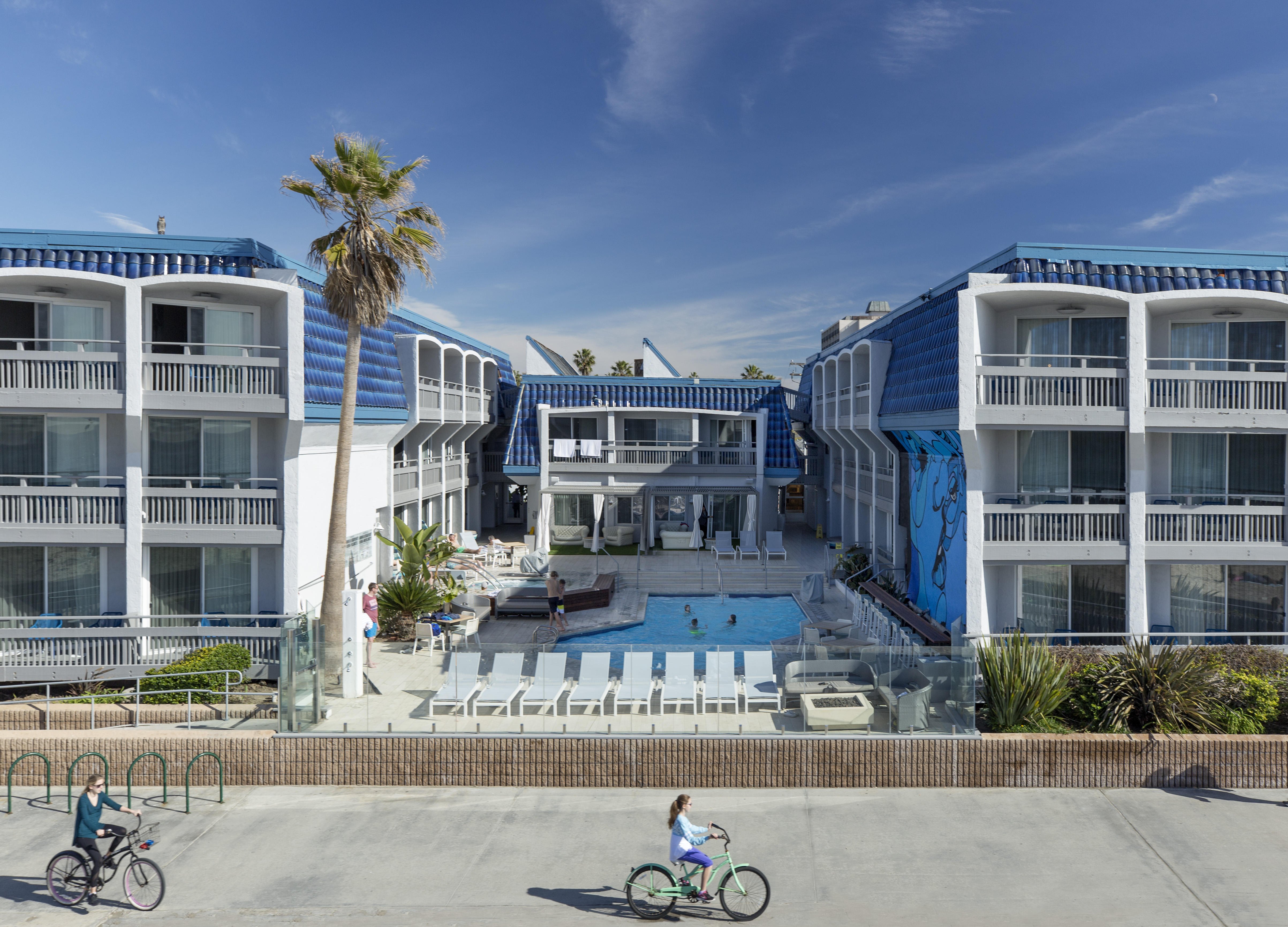 A girl on a bike in front of Blue Sea Beach Hotel