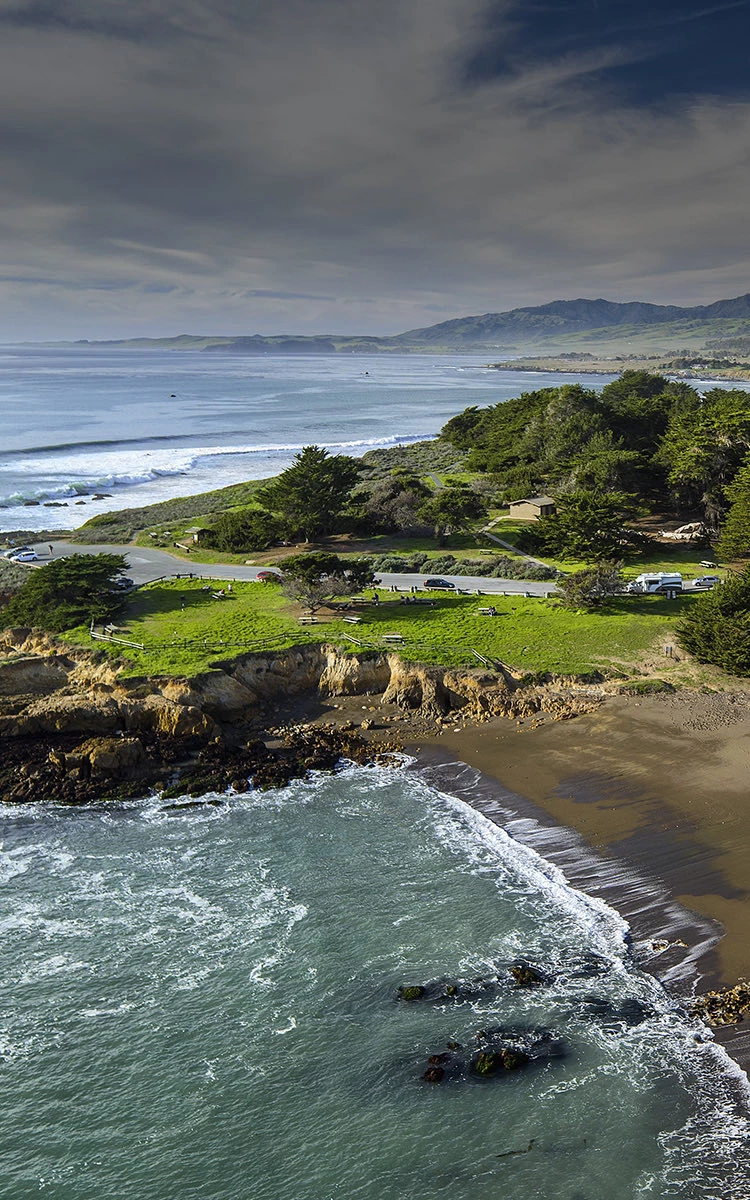 aerial view of waves crashing on the shore with dark overlay