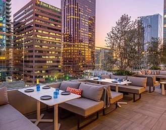 Rooftop in the middle of the city with gray sofas and building on the back