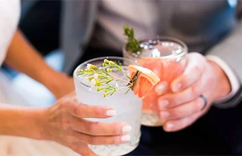a group of hands holding glasses with liquid in them