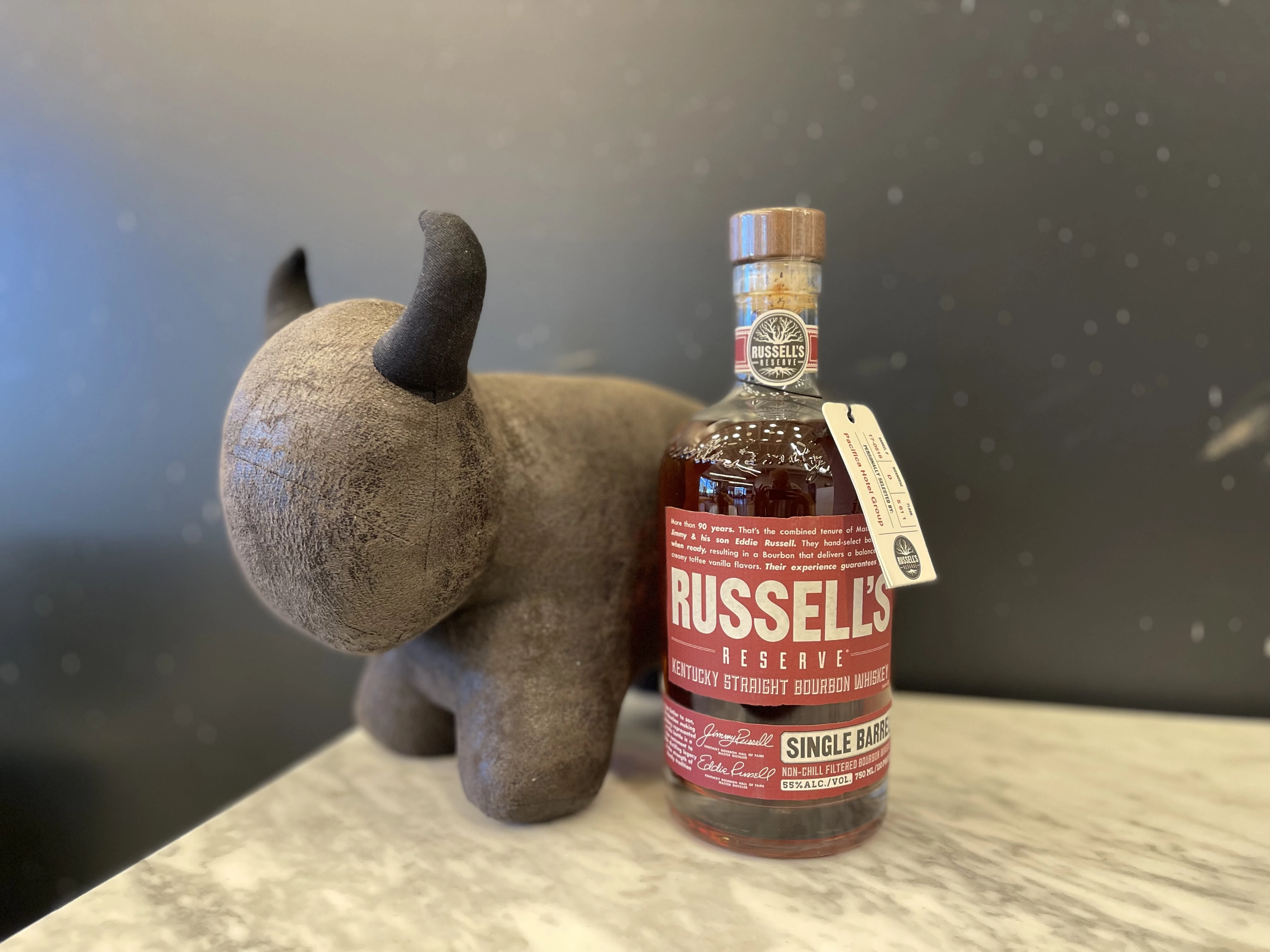 a stuffed animal next to a bottle of liquor