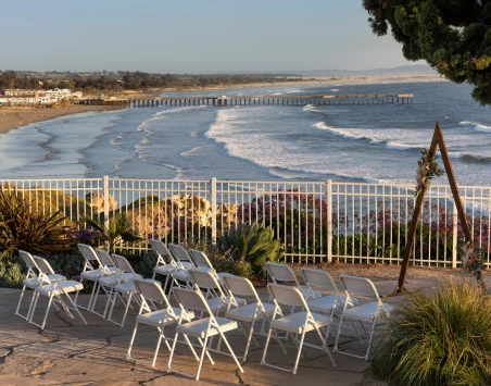a beach with white chairs and tables
