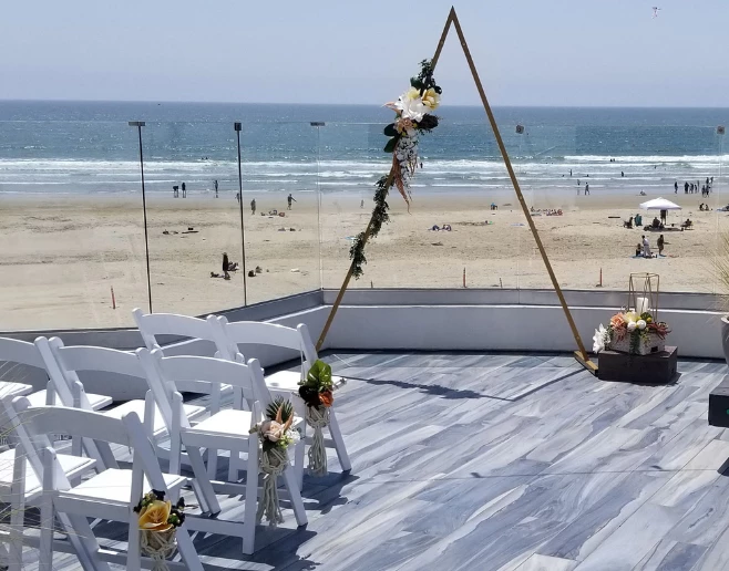 a beach with white chairs and tables
