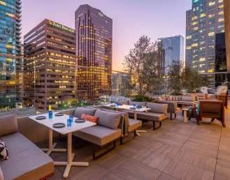 a room with a table and chairs and a group of tall buildings