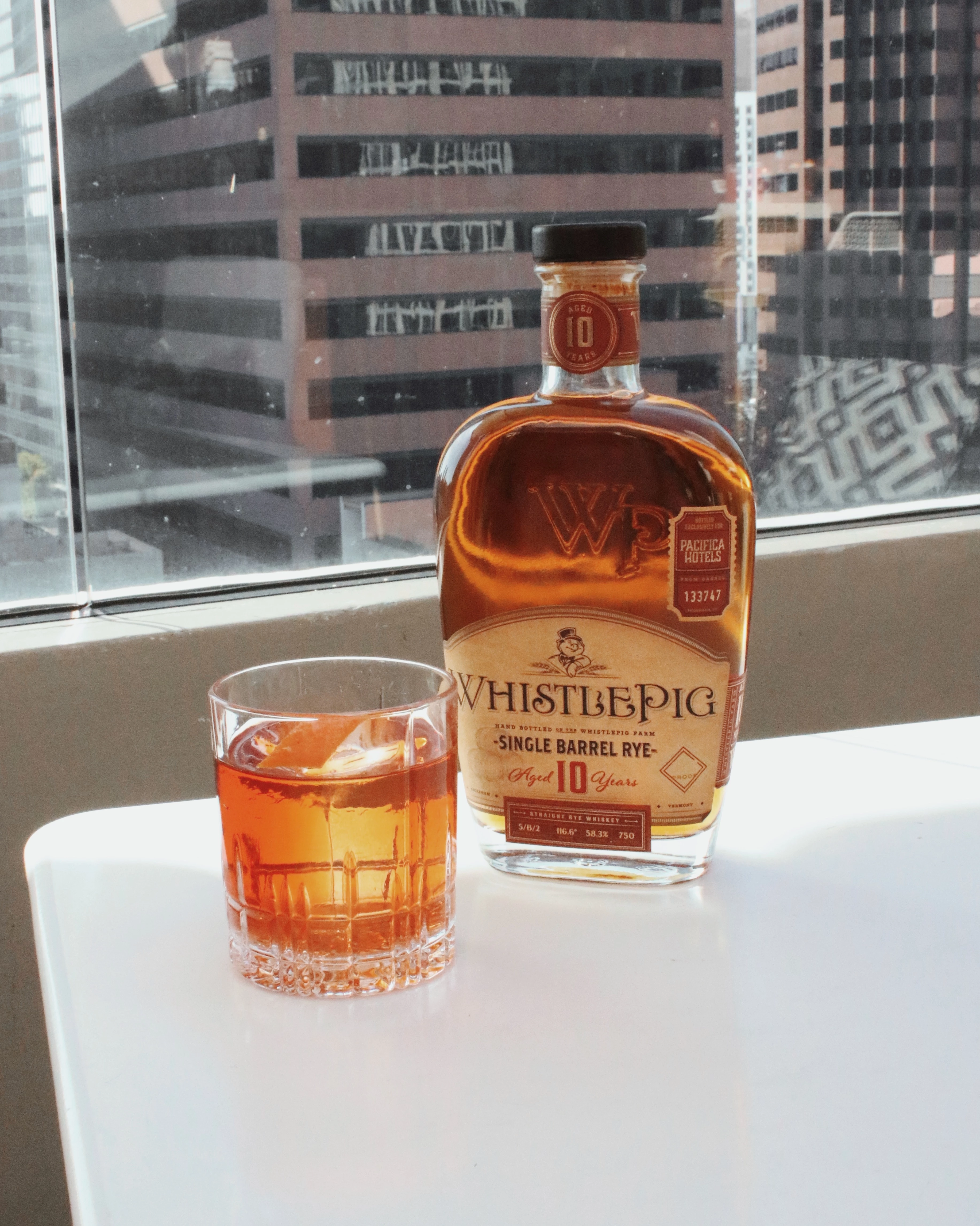 a bottle of alcohol next to a glass of amber liquid