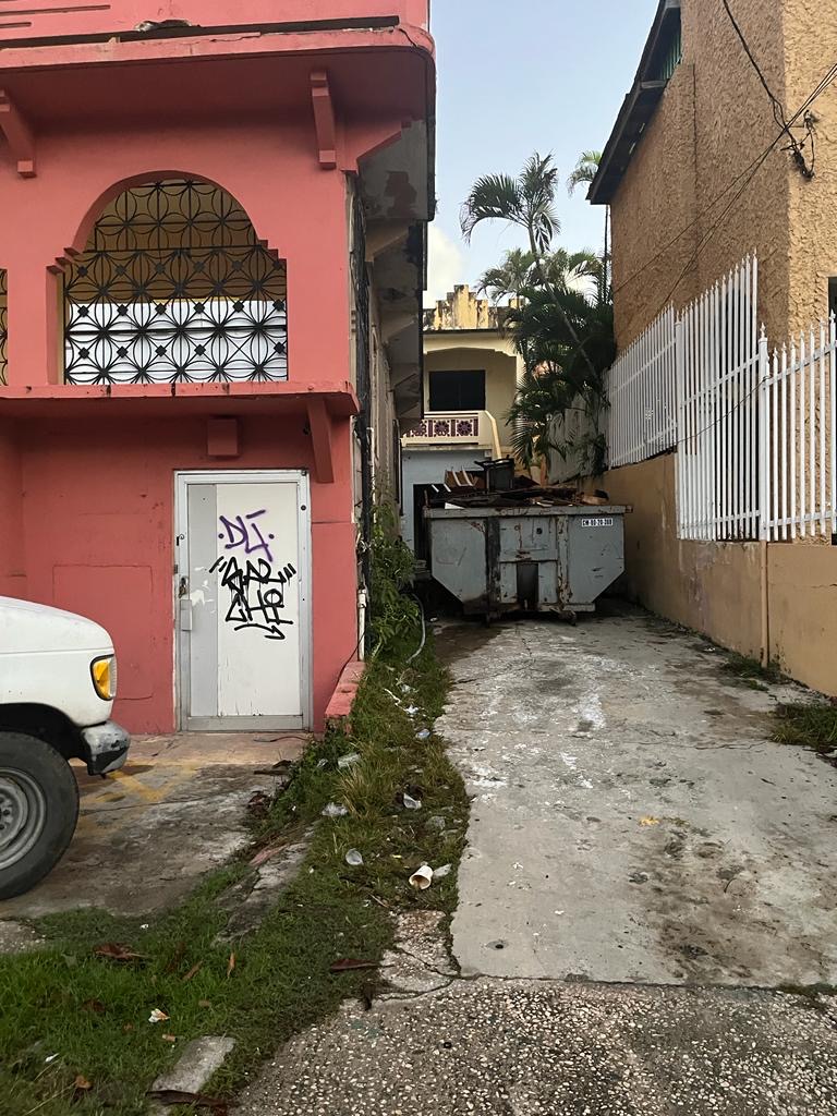 a street with buildings and a white fence
