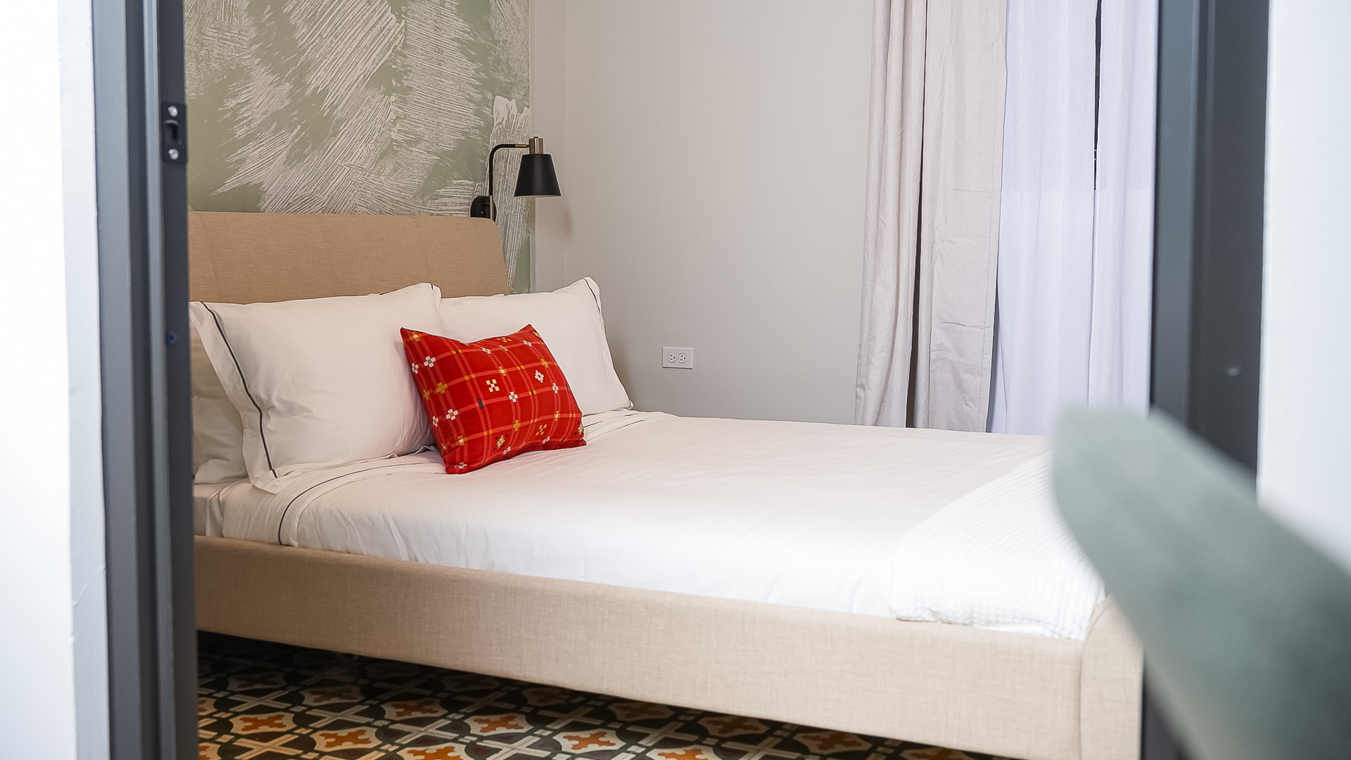 a bed with a lamp and a vase on it