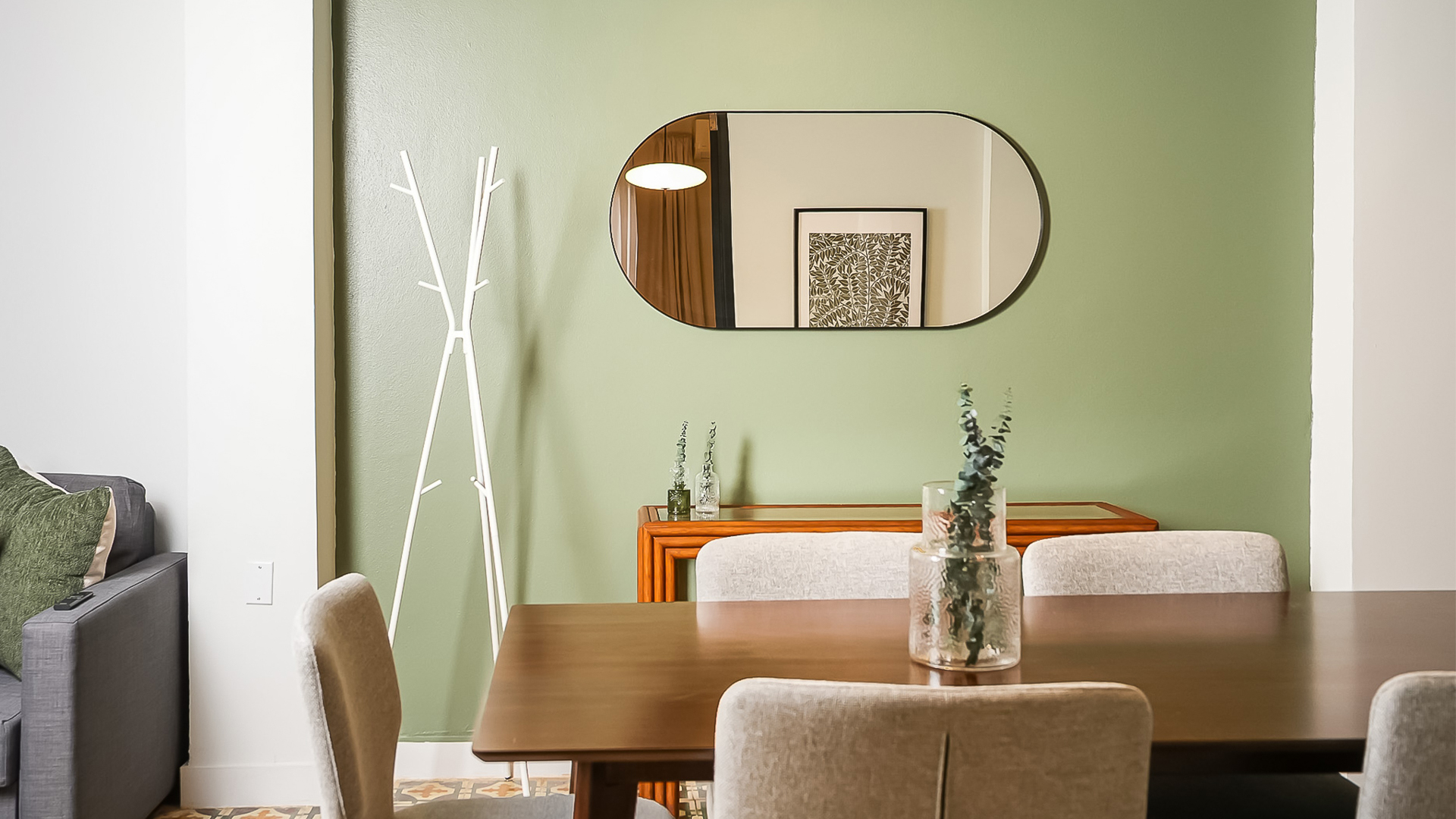 a dining table with chairs and a mirror on the wall