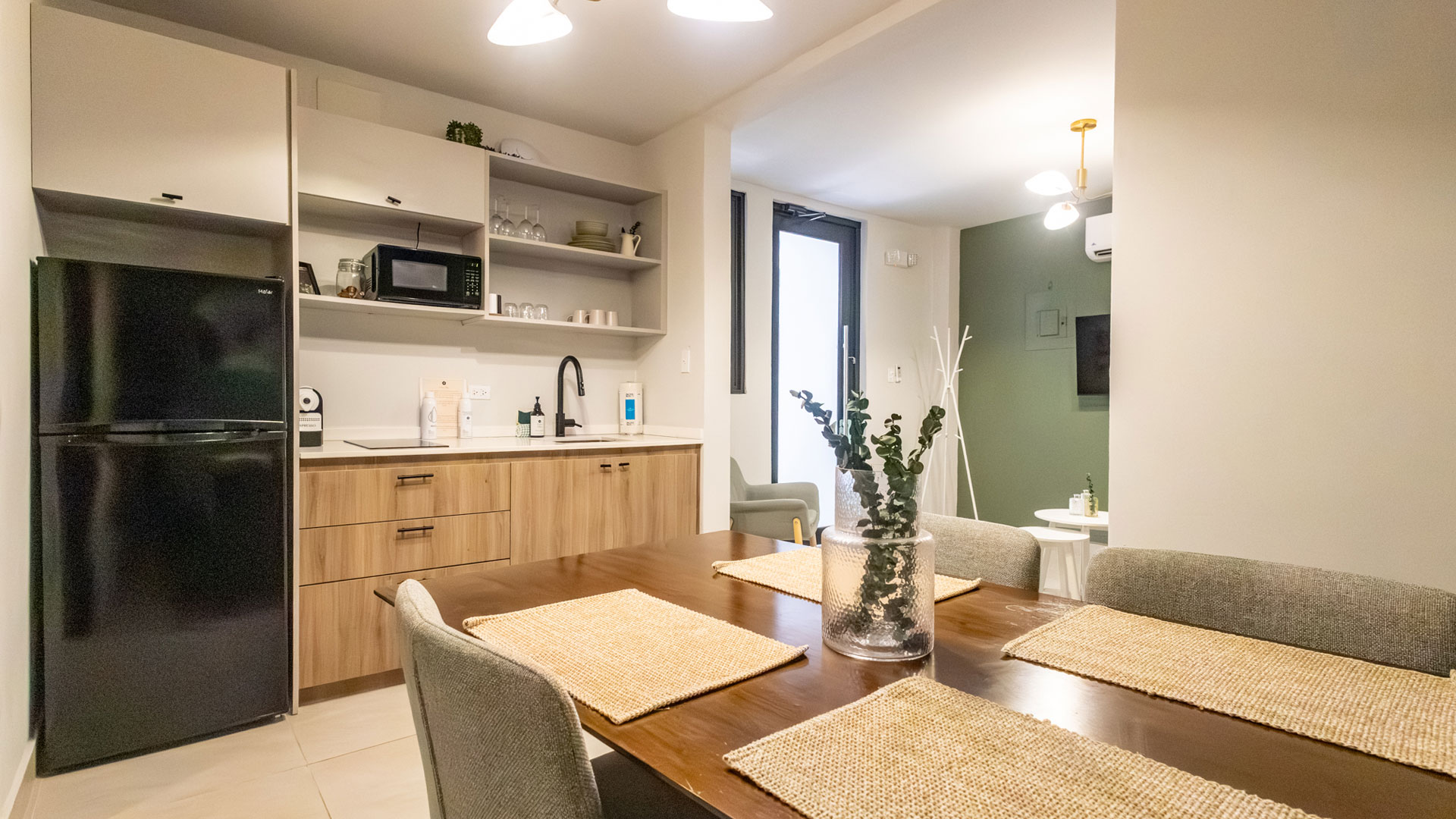 a dining table with chairs and a television in the background