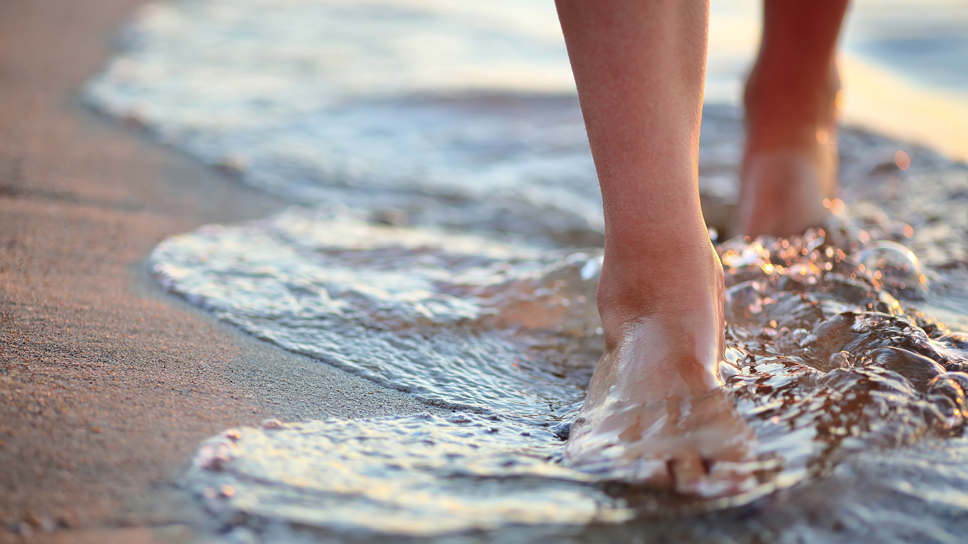 a person's foot on the beach