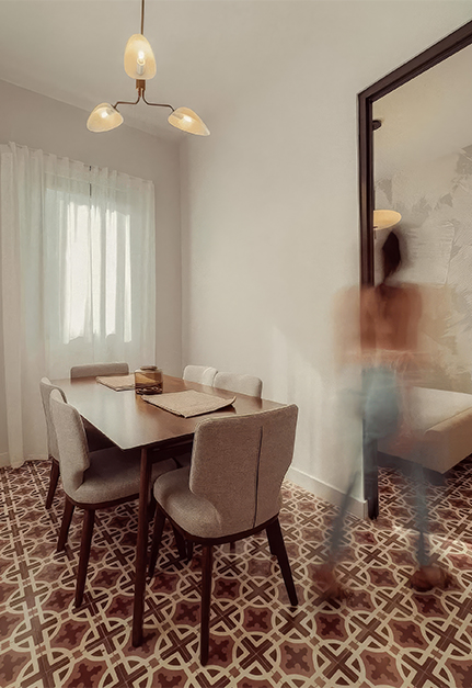 a blurry image of a person walking by a table and chairs