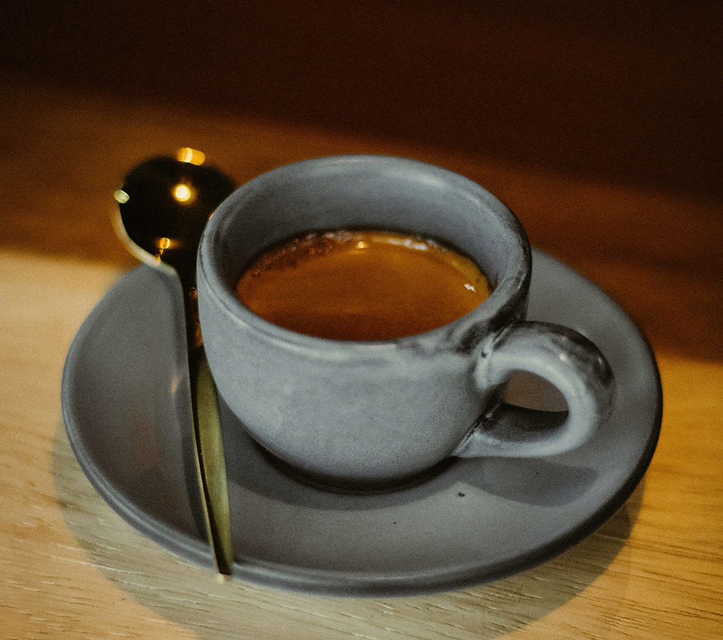 a cup of coffee with a spoon on a saucer