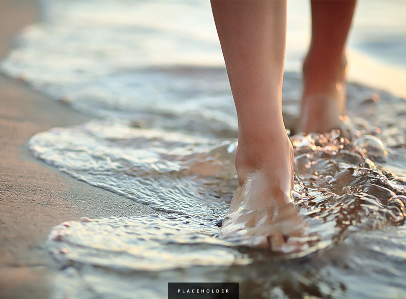 a person's feet walking in water