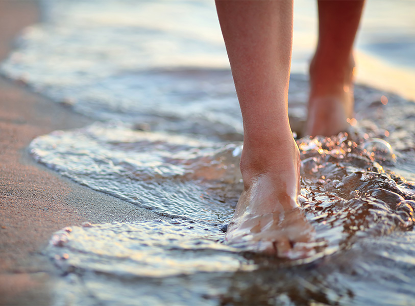a person's feet walking in water