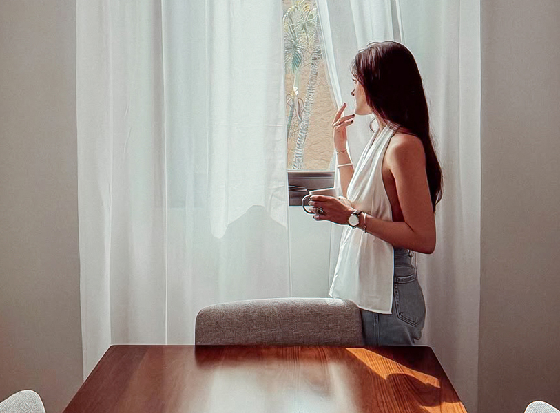 a woman standing by a window