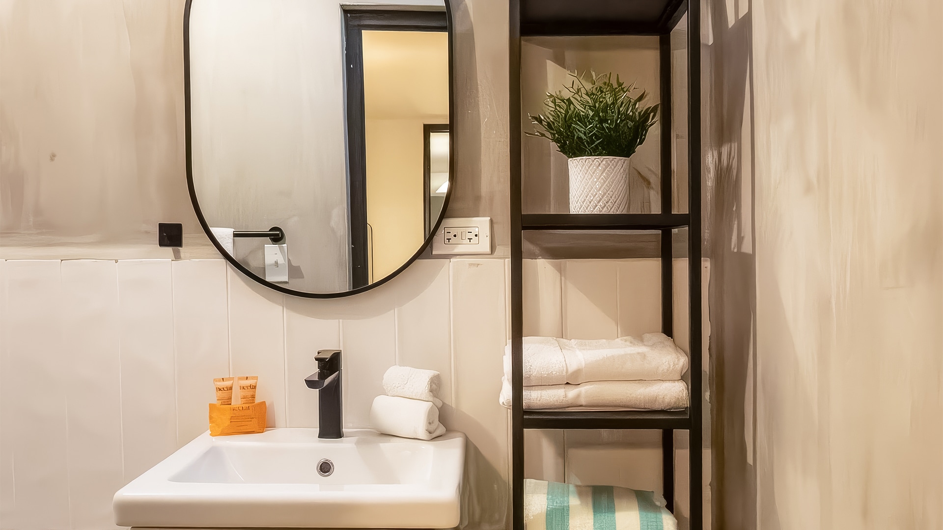 a bathroom with a mirror and a shelf with towels