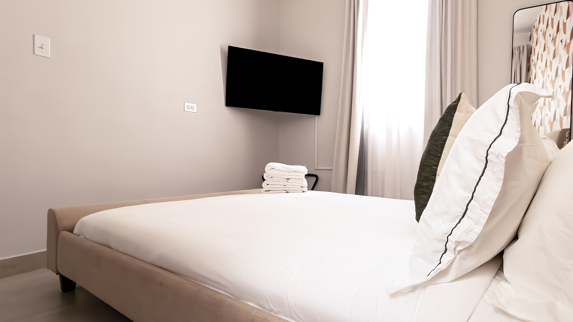 a bed with white sheets and towels on it